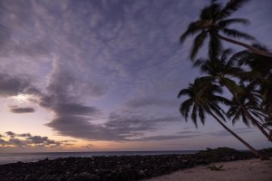 The crescent moon hangs in the sky as sunrise starts to outshine the other stars as seen from Lighthouse Caye off the coast of Belize.